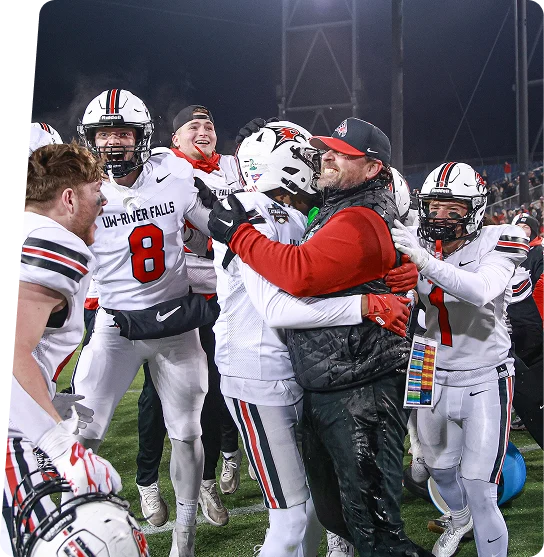 Football players celebrating with their coach on the field